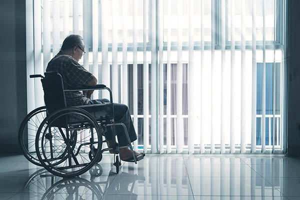 Man in wheelchair in front of window
