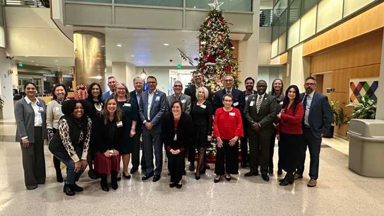 Moffitt PFAC members in front of Christmas tree