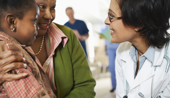 Grandmother and granddaughter talking to doctor